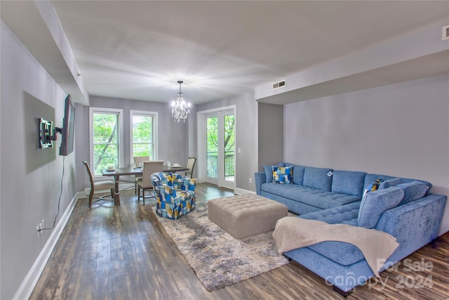 living room featuring dark wood-type flooring and a notable chandelier