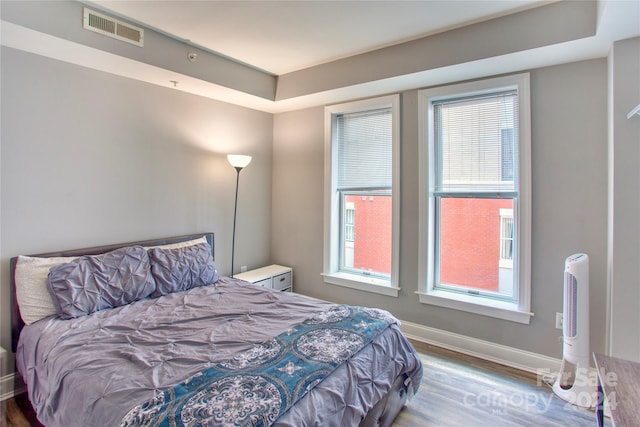 bedroom featuring wood-type flooring and multiple windows