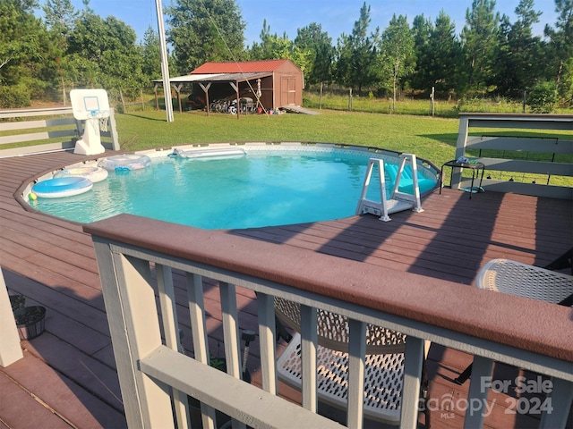 view of pool with a yard, a deck, a gazebo, and a storage unit