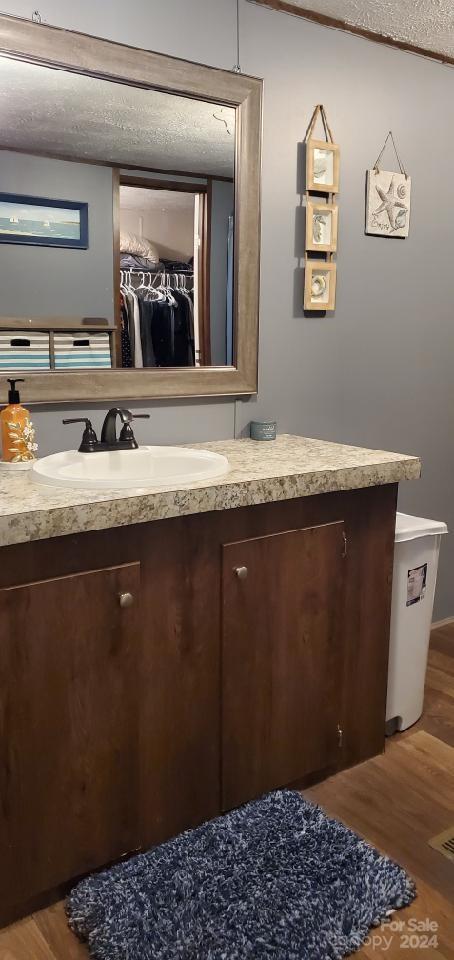 bathroom featuring vanity, hardwood / wood-style floors, and a textured ceiling