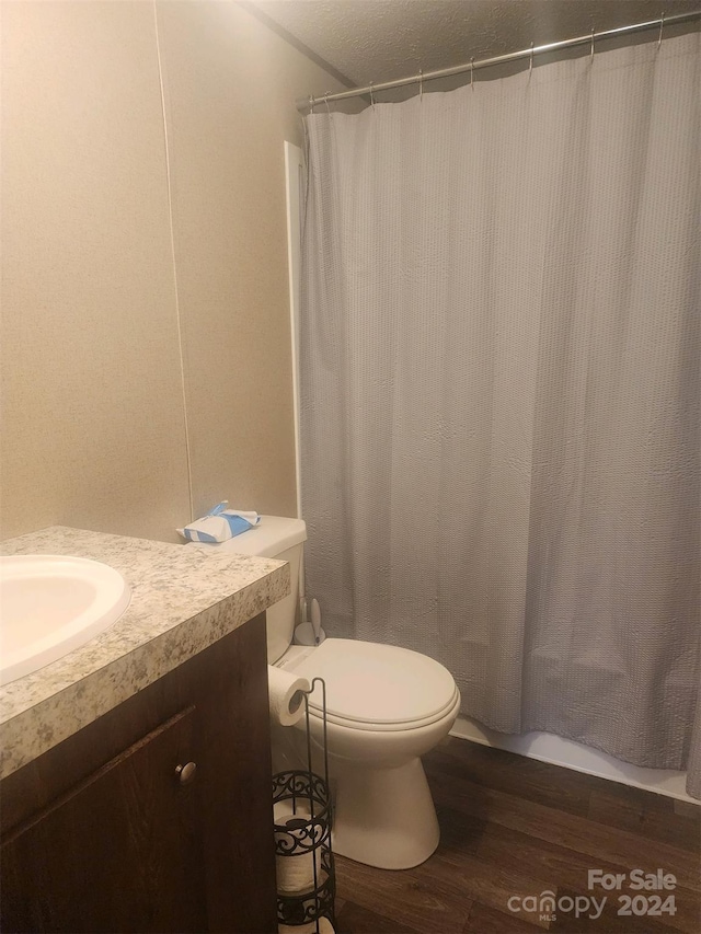 bathroom with vanity, hardwood / wood-style flooring, toilet, and walk in shower