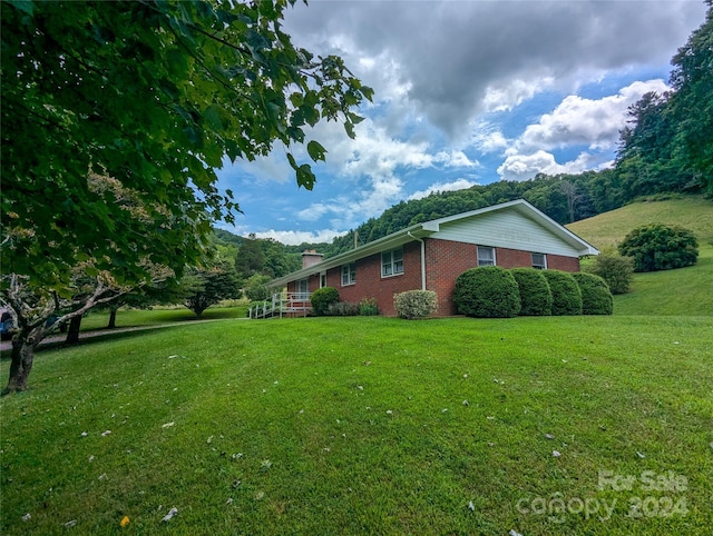 view of side of home with a yard