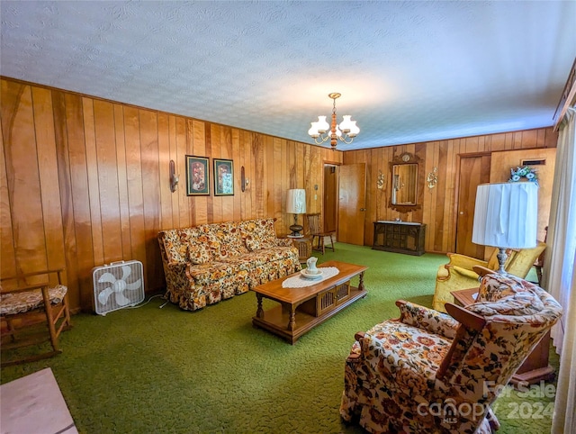 carpeted living room featuring wooden walls, a textured ceiling, and a notable chandelier