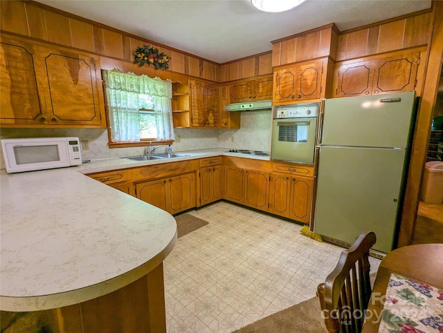 kitchen featuring sink, white appliances, and kitchen peninsula