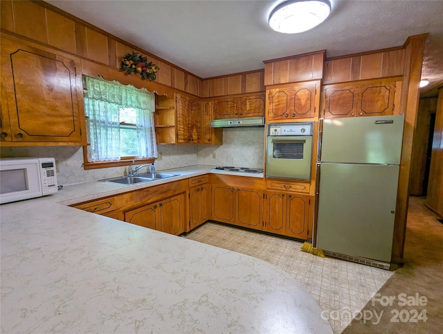 kitchen featuring white appliances, sink, and decorative backsplash