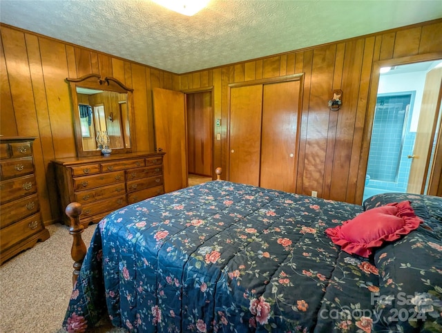 carpeted bedroom with wooden walls, a closet, and a textured ceiling