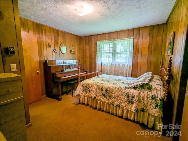 carpeted bedroom with a textured ceiling and wood walls