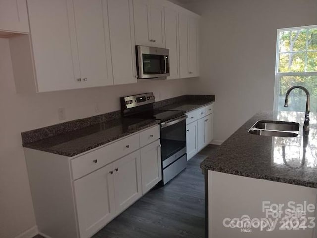 kitchen with dark stone countertops, sink, white cabinets, and appliances with stainless steel finishes