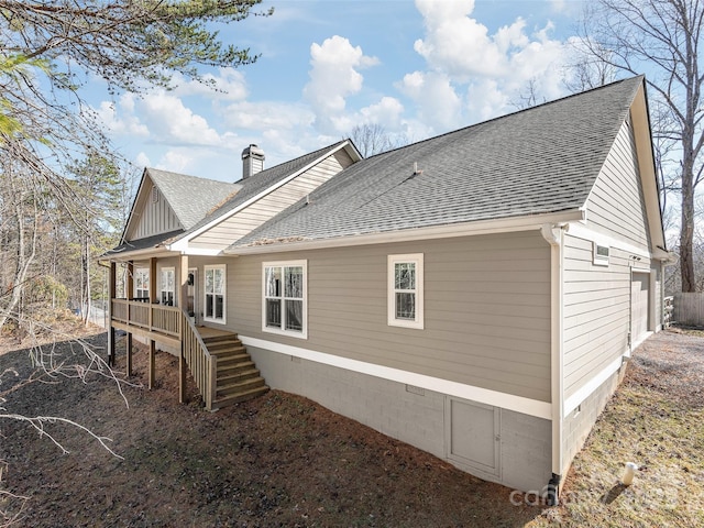 back of property featuring crawl space, a shingled roof, stairs, and a chimney