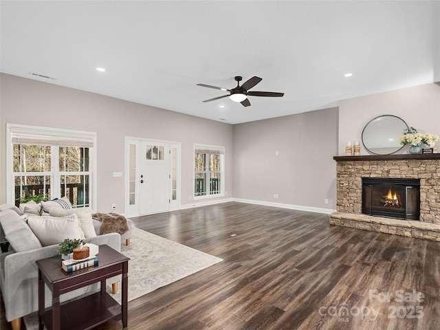 living room with dark wood-style flooring, a fireplace, recessed lighting, visible vents, and baseboards