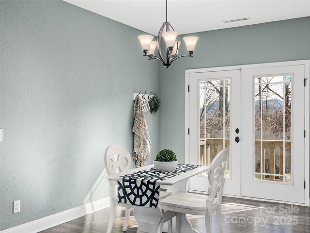 dining area with baseboards, visible vents, dark wood finished floors, an inviting chandelier, and french doors