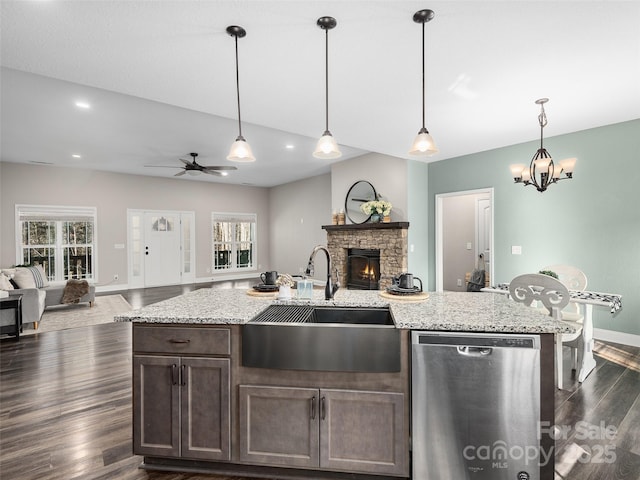 kitchen with a sink, dark wood-type flooring, open floor plan, and dishwasher