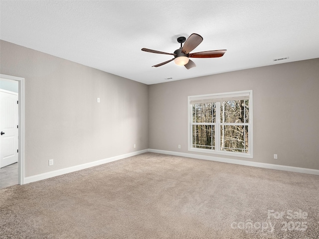 empty room with baseboards, visible vents, ceiling fan, a textured ceiling, and carpet floors