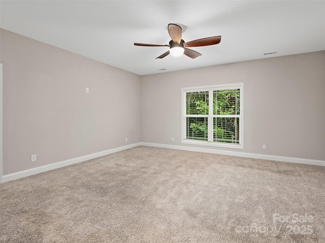 spare room featuring ceiling fan, carpet, visible vents, and baseboards