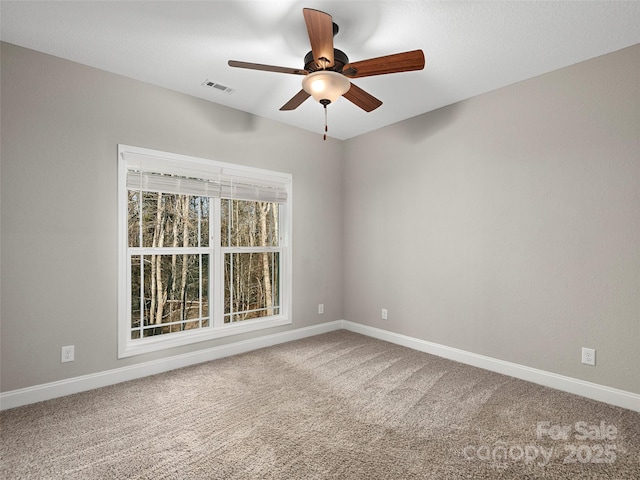 unfurnished room featuring ceiling fan, carpet, visible vents, and baseboards