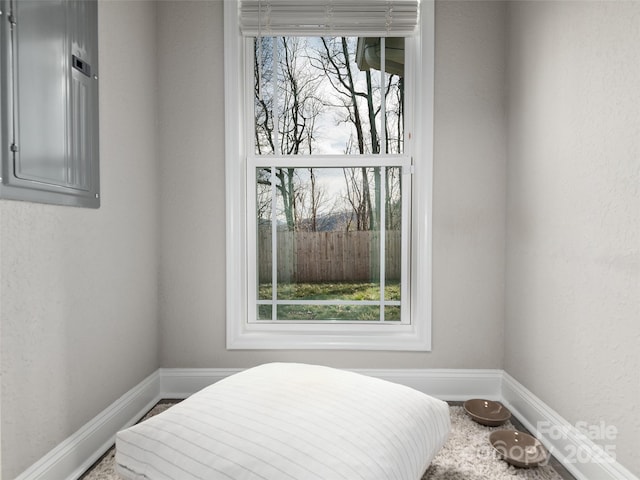 bedroom featuring electric panel and baseboards