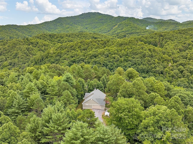 drone / aerial view featuring a mountain view and a view of trees