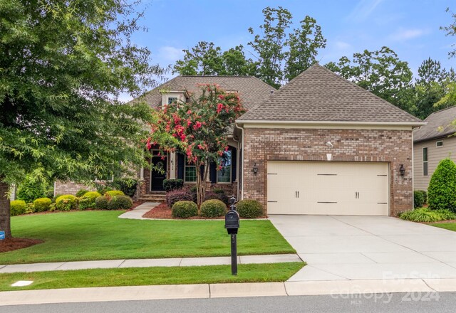 view of front of house featuring a garage and a front lawn