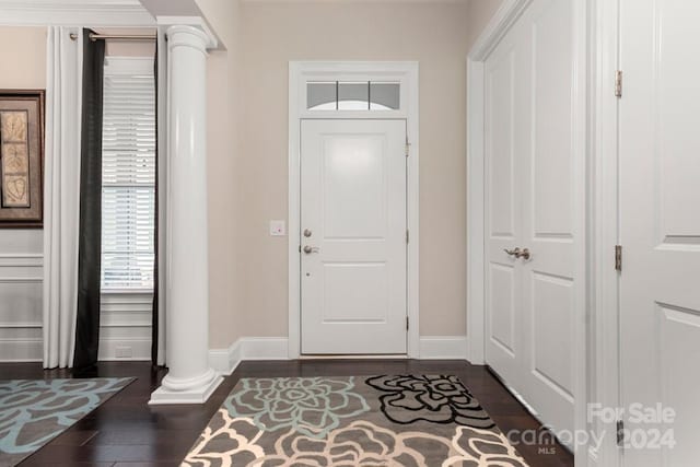 entrance foyer with decorative columns and dark hardwood / wood-style flooring