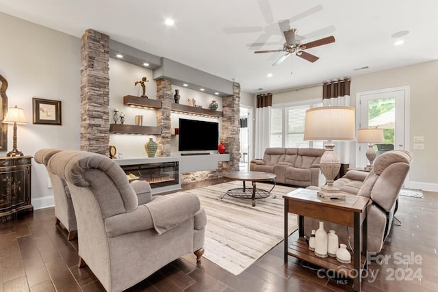 living room with ceiling fan and a fireplace