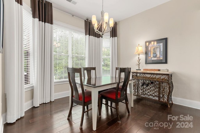 dining space featuring dark hardwood / wood-style floors and a chandelier