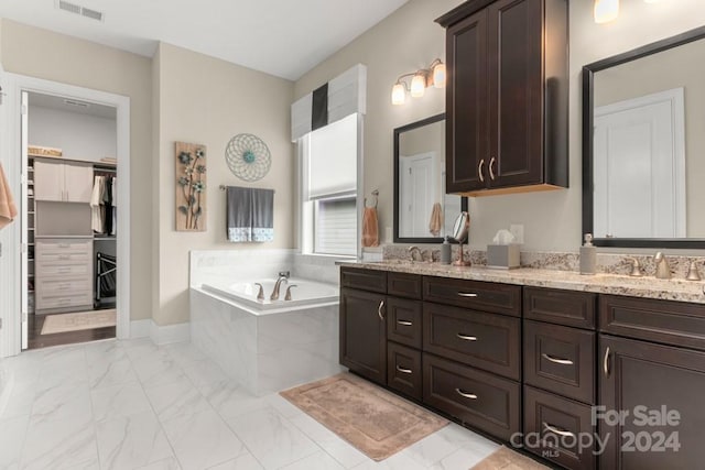 bathroom with vanity and a relaxing tiled tub