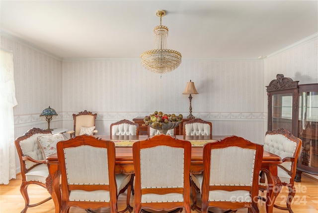 dining room with hardwood / wood-style flooring, crown molding, and a chandelier