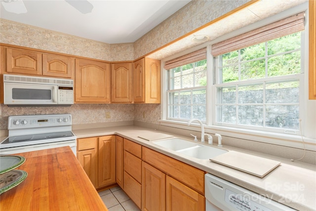 kitchen with white appliances, wooden counters, sink, light tile patterned flooring, and ceiling fan