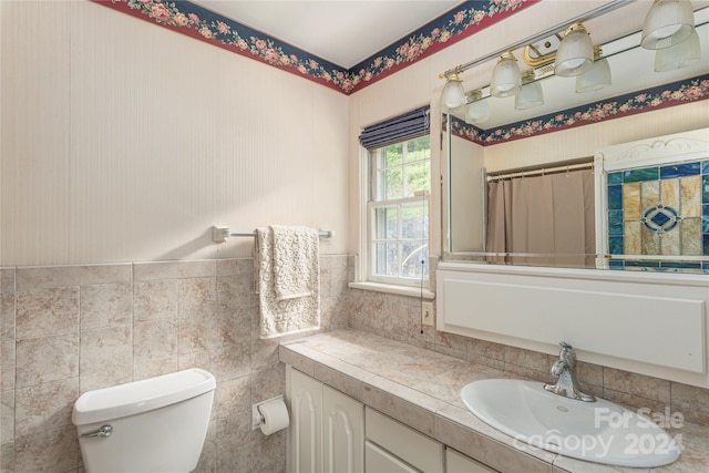 bathroom featuring tile walls, toilet, and vanity