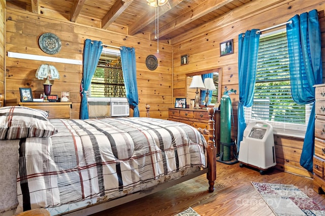 bedroom with wood walls, wood ceiling, hardwood / wood-style floors, and beam ceiling