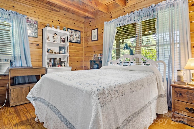 bedroom with hardwood / wood-style floors, beamed ceiling, wood ceiling, and wooden walls