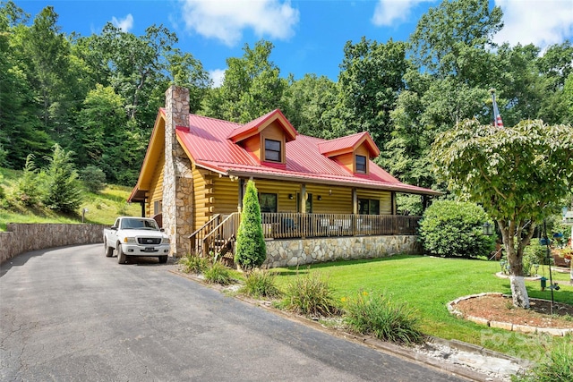 log cabin with a front yard and covered porch