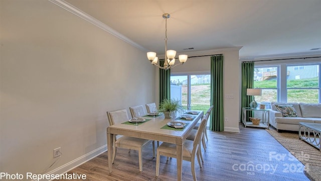 dining area with an inviting chandelier, crown molding, and hardwood / wood-style flooring