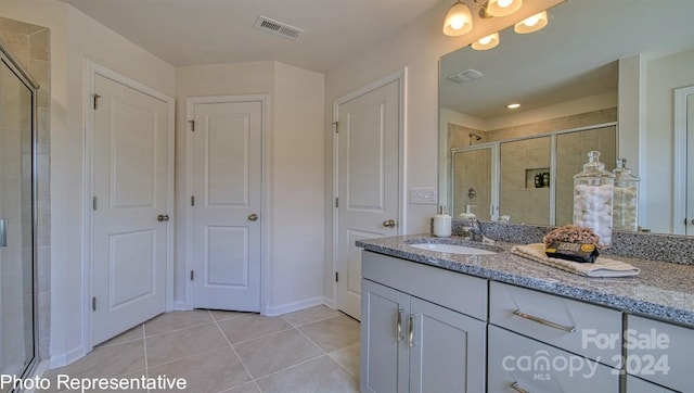 bathroom featuring vanity, a shower with door, and tile patterned floors