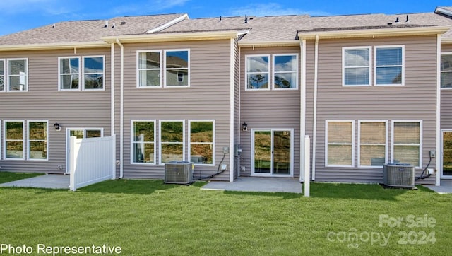 rear view of property with central AC unit, a patio area, and a lawn