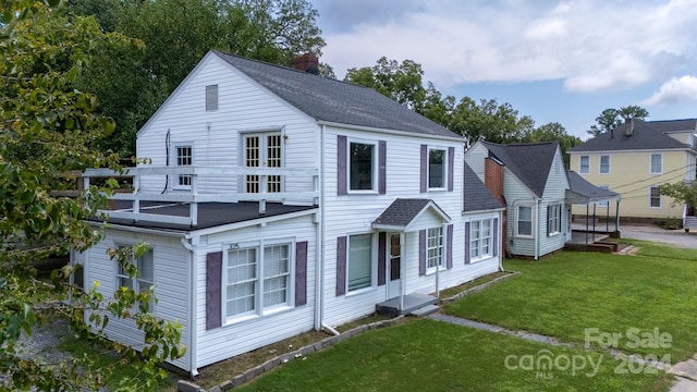 view of front of property with a front lawn and a balcony