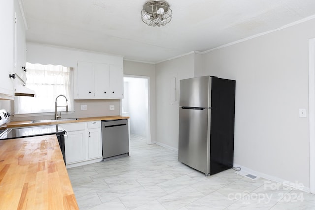 kitchen with sink, white cabinetry, crown molding, wooden counters, and appliances with stainless steel finishes