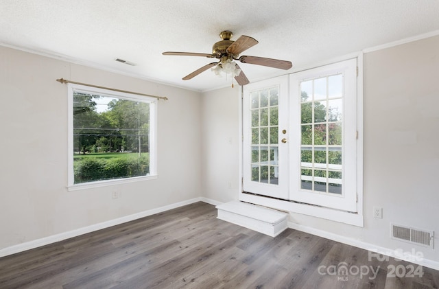 empty room with wood-type flooring, ceiling fan, a textured ceiling, and french doors