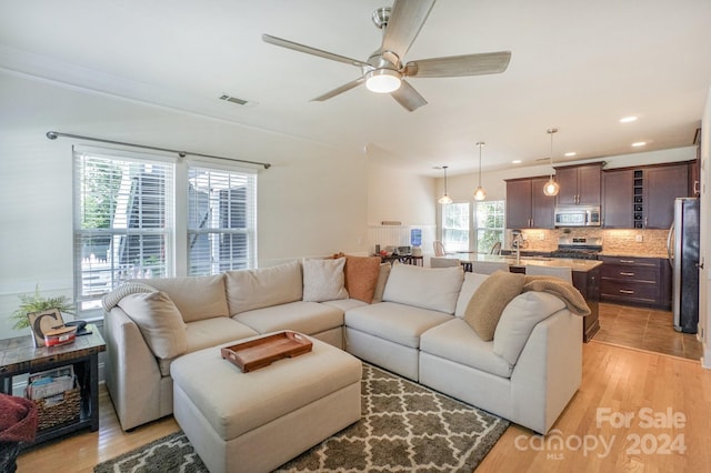 living room featuring ceiling fan and light hardwood / wood-style floors