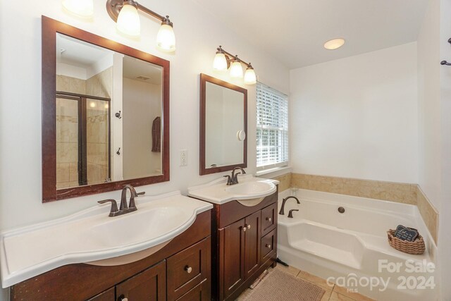 bathroom featuring independent shower and bath, tile patterned flooring, and dual bowl vanity