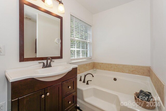 bathroom with vanity and a tub to relax in