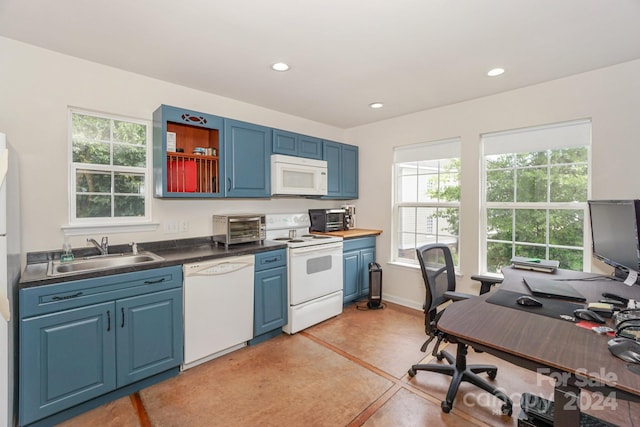 kitchen featuring light tile patterned flooring, blue cabinets, white appliances, and sink