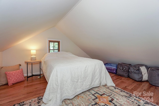 bedroom featuring hardwood / wood-style flooring and vaulted ceiling