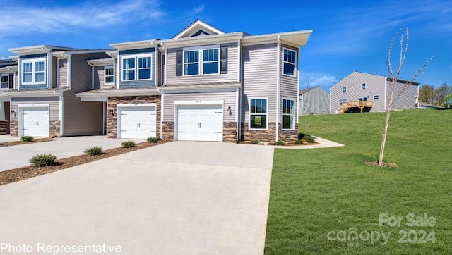 townhome / multi-family property featuring an attached garage, stone siding, concrete driveway, and a front yard