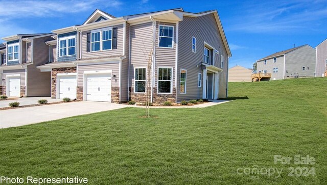 view of front of home with driveway, stone siding, a garage, and a front yard