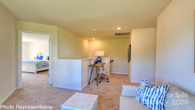 interior space with light carpet, baseboards, a kitchen bar, and visible vents