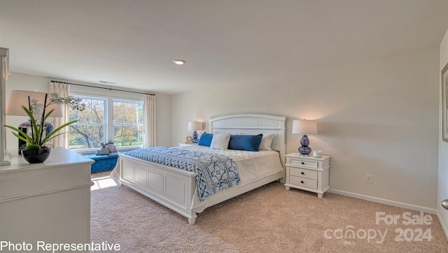 bedroom with light carpet, visible vents, and baseboards