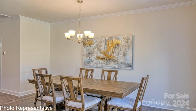 dining room with dark wood-style floors, baseboards, ornamental molding, and an inviting chandelier