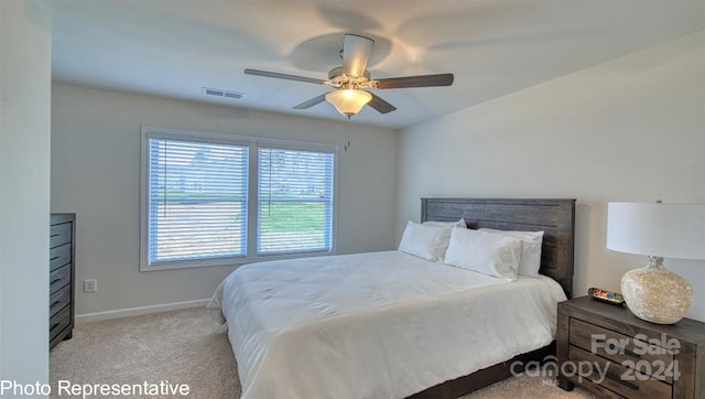 bedroom with light carpet, a ceiling fan, visible vents, and baseboards