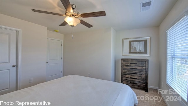 bedroom featuring a ceiling fan, light colored carpet, and visible vents